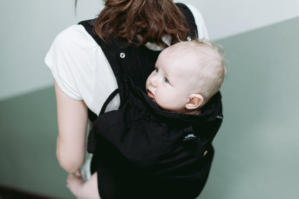 Weego ORIGINAL baby carrier: young mom carrying baby on her back
